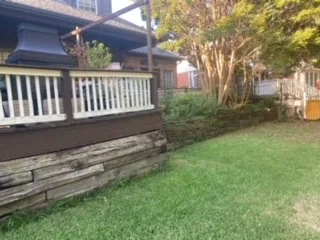 New Milsap stone retaining wall replacing old railroad cross-tie wall along residential deck in Colleyville TX
