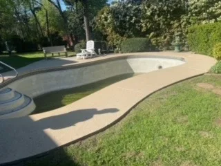 Partial Pool & Deck Demolition – JCL Landscaping DFW Empty residential pool with surrounding concrete decking before partial demolition and removal service in DFW