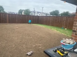 Freshly graded backyard after partial pool and deck demolition, compacted soil ready for use, DFW residential property