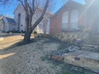 Failing Retaining Wall & Steps Before Demo – Carrollton TX Deteriorating stone retaining wall and aging landscape steps at a brick home in Carrollton TX, before demolition and wall replacement