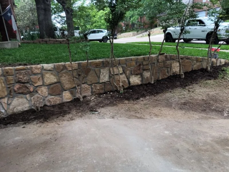New Milsap stone retaining wall replacing a failed cross-tie wall along a residential driveway in Grapevine, TX