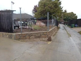 Completed Milsap stone retaining wall replacing a deteriorated wood wall along a residential driveway in Lewisville, TX