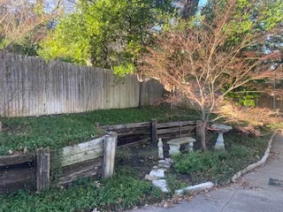 Failing Railroad Tie Wall Before Replacement | Colleyville TX Deteriorating railroad tie retaining wall with rotting timbers leaning and separating in a DFW backyard before replacement with Milsap stone