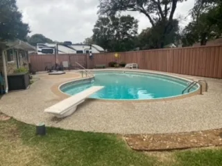 Residential Pool Before Removal – Plano TX | JCL Landscaping Round in-ground residential swimming pool with diving board and aggregate concrete deck in Plano, TX before pool removal demolition
