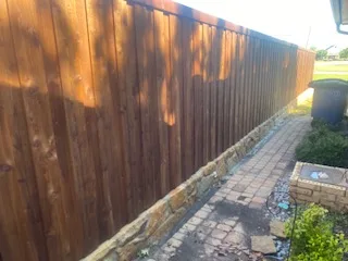 New Milsap stone base retaining wall with freshly stained 6-ft wood privacy fence along brick paver path in Allen, TX