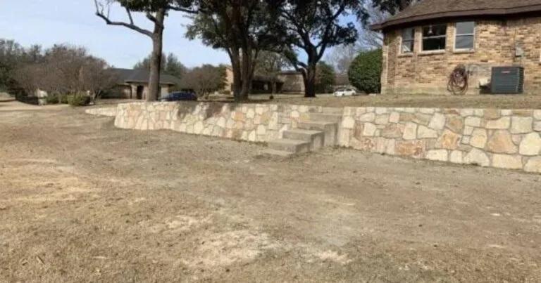 New Milsap stone retaining wall with concrete steps replacing a failed crosstie wall at a Plano TX home, terracing the front yard