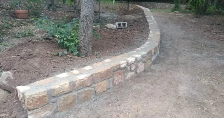 Curved Milsap stone retaining wall newly built around a tree bed in Arlington TX backyard, DFW clay-soil construction