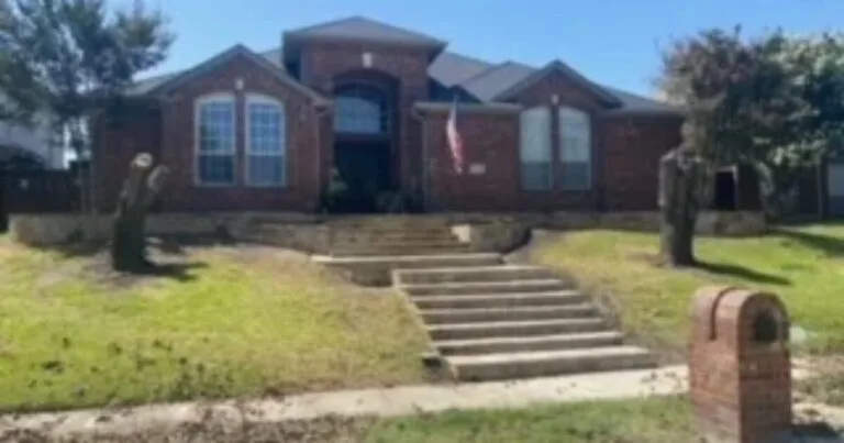 Brick home in Carrollton TX with aging concrete staircase and low stone retaining wall along front yard slope before demolition and replacement