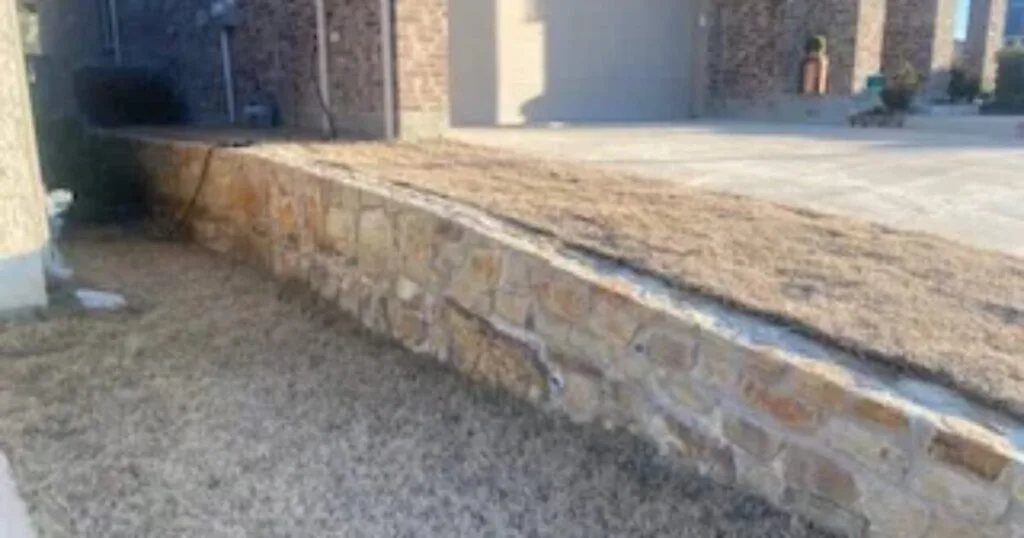 New Milsap stone added to top of existing front-yard retaining wall beside brick home driveway in Colleyville TX