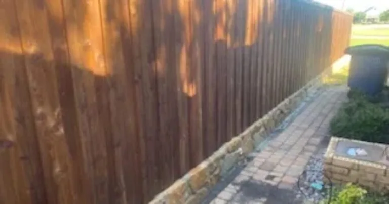 New Milsap stone retaining wall along a wood privacy fence with brick paver path in Allen, TX