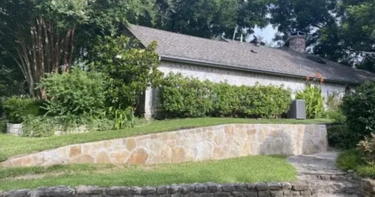 Rebuilt tiered Milsap stone retaining walls holding a raised lawn beside a single-story DFW home, McKinney TX
