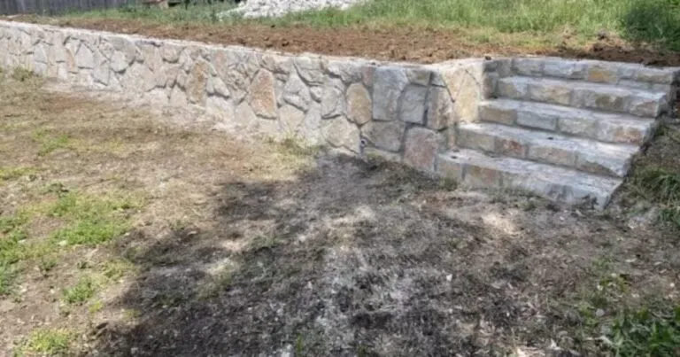 Newly built Milsap stone retaining wall with integrated stone steps replacing a failed crosstie wall in Flower Mound, TX backyard
