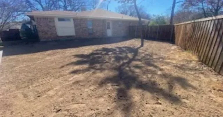 Flat graded backyard after complete pool removal and backfill in Coppell TX, showing smooth compacted soil ready for new use beside a brick home and wood fence