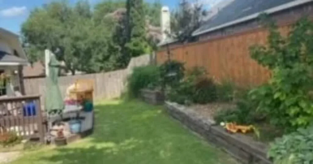 Aging railroad-tie retaining wall bordering a residential backyard in Dallas, TX — a common replacement candidate for JCL Landscape Services