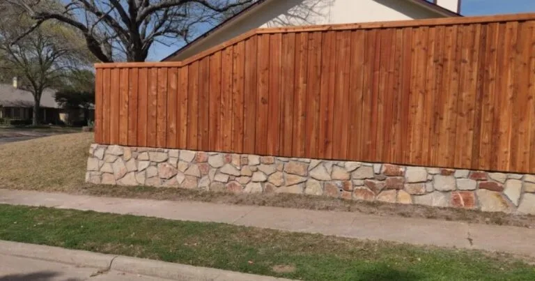 Stone retaining wall base topped with cedar wood privacy fence along a residential street in Plano, TX