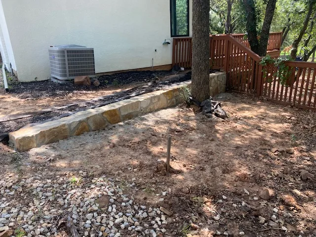 Retaining wall base course and drainage aggregate under construction on an Argyle slope