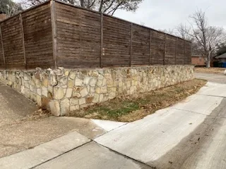 Rebuilt stone retaining wall on a new base along a Carrollton street frontage