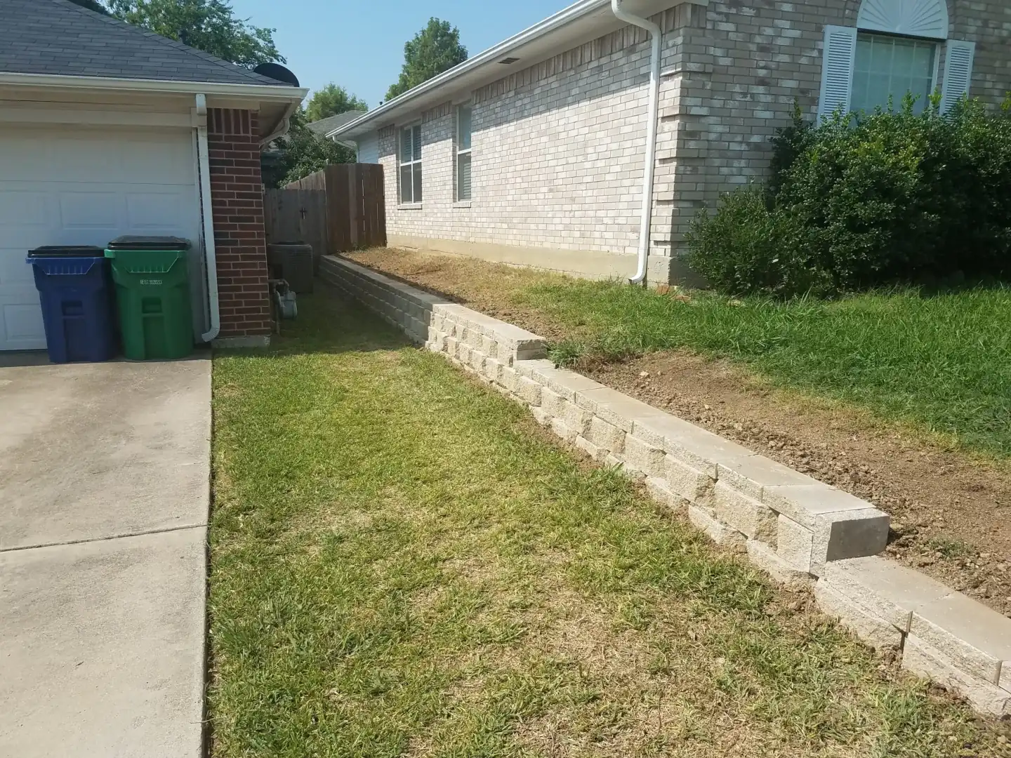 Concrete block retaining wall front yard slope — a JCL Landscape Services project in the Dallas–Fort Worth metroplex
