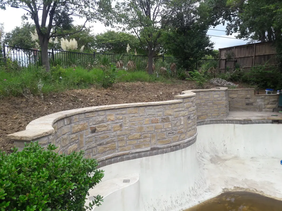 Curved stone retaining wall pool edge — a JCL Landscape Services project in the Dallas–Fort Worth metroplex