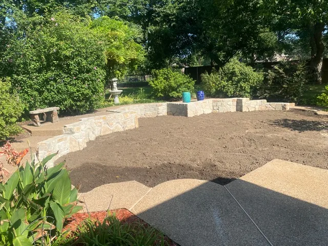 Curved Milsap stone retaining wall after pool removal — Flower Mound TX New curved Milsap stone retaining wall holding restored grade after pool removal in Flower Mound