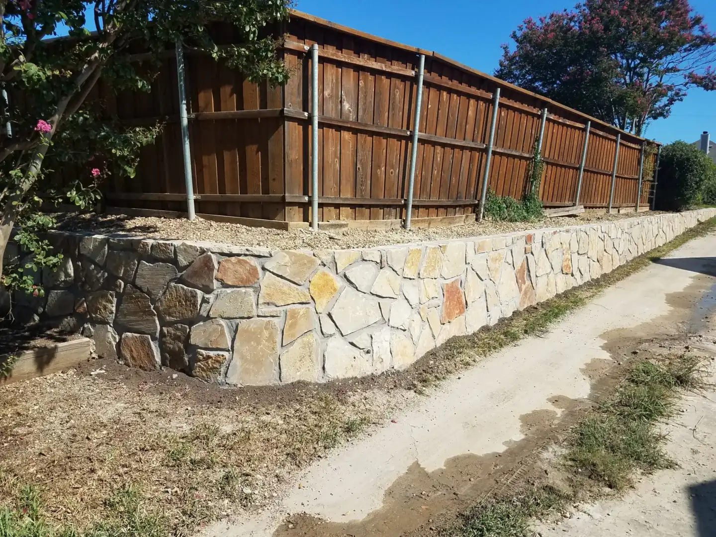 Granbury stone retaining wall fence line — a JCL Landscape Services project in the Dallas–Fort Worth metroplex