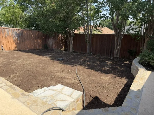 Levelled Lewisville back yard with a new Milsap stone retaining wall after pool removal