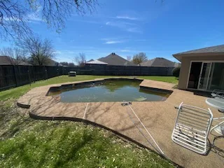 Swimming pool before demolition — North Richland Hills TX Partially drained swimming pool in a North Richland Hills back yard before demolition
